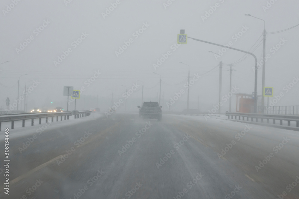 Snowy winter road during blizzard. Heavy snow storm. Snowy winter road during blizzard. Heavy snow storm.