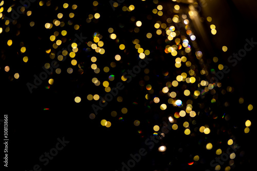 Abstract bokeh made from Christmas lights in the shop on black background. Holiday concept, overlay for your images.