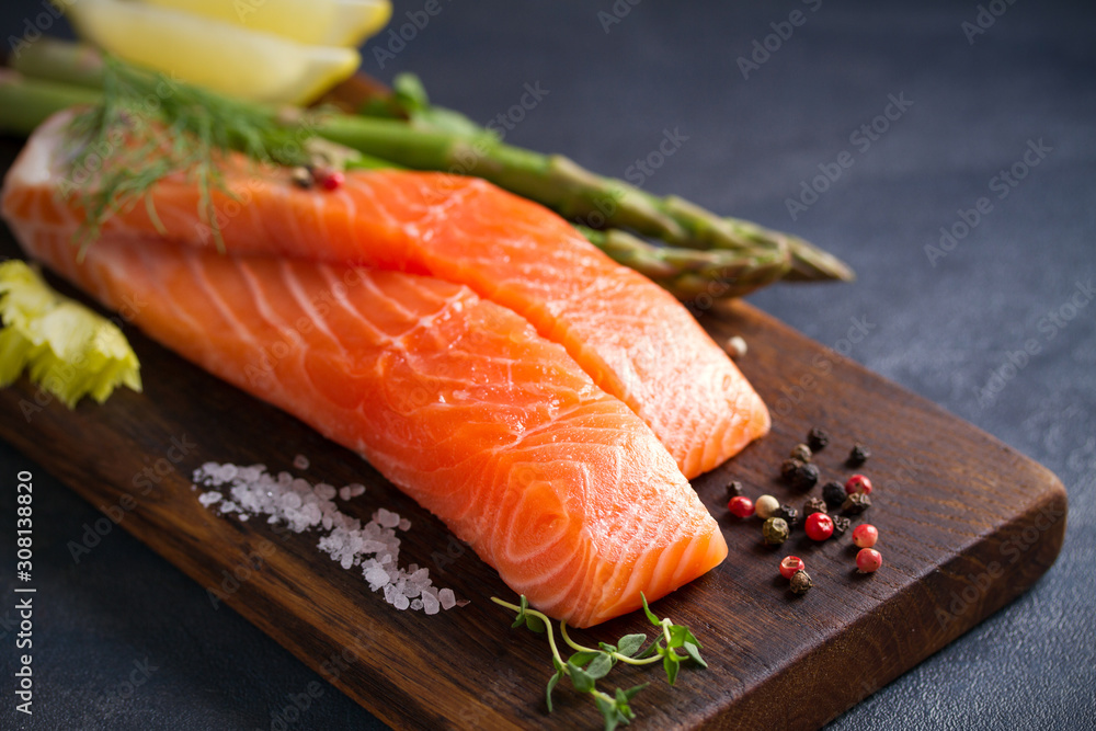 Fresh raw salmon fillet steak with vegetables and ingredients prepared for cooking Fresh raw salmon fillet steak with vegetables and ingredients prepared for cooking