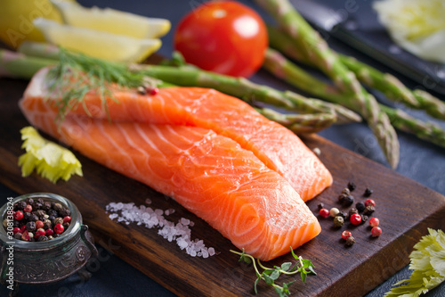 Fresh raw salmon fillet steak with vegetables and ingredients prepared for cooking