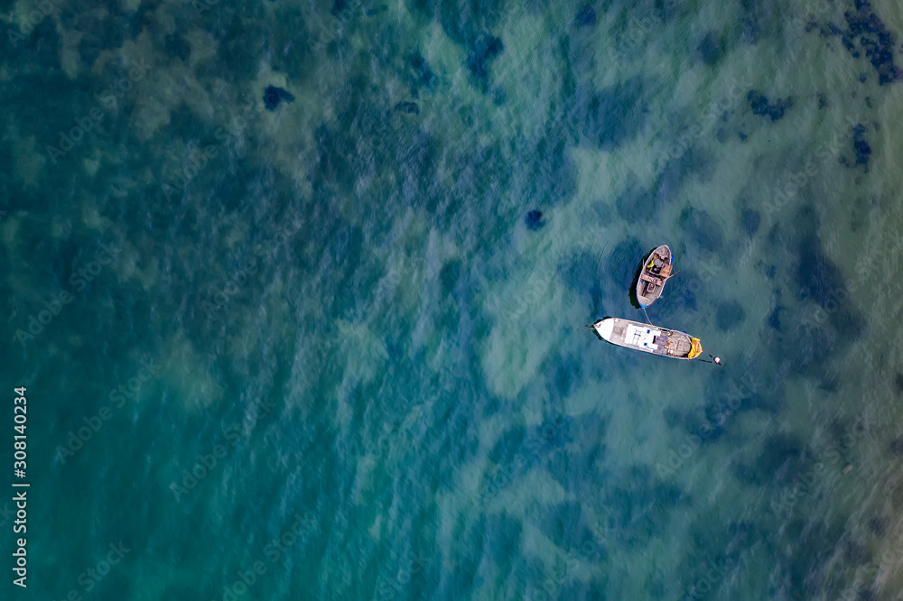 Fototapeta premium Aerial view of the fishing boats in clear blue water at sunset. Landscape with sailboats, sea. Seascape