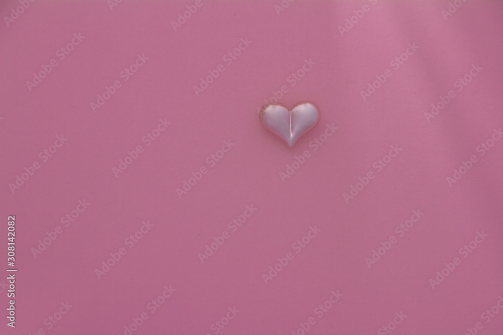 Close-up of a pink heart on a pink pastel background, selective focus