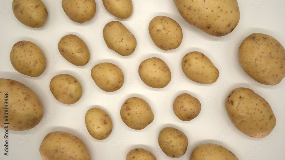 Fototapeta premium Young white potato, top view. Isolated potatoes on a white background. Fresh food for vegetarians. Raw vegetable, root vegetable. Photo harvesting potatoes for a designer.