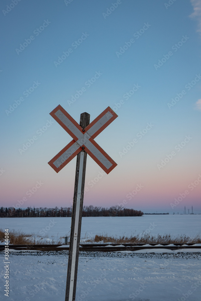 Traditional Railroad Crossing Sign at Sunset in Winter Vertical Crop Traditional Railroad Crossing Sign at Sunset in Winter Vertical Crop