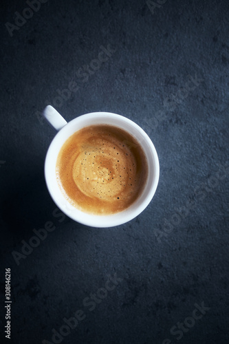 Cup of coffee on dark stone background. Top view. Copy space