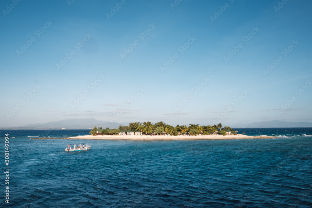 Boat sailing towards a small inhabited island in group of Yasawa, Fiji