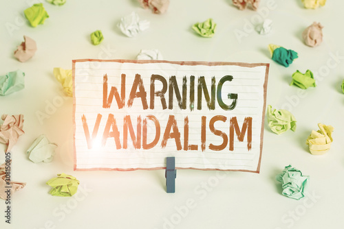 Handwriting text writing Warning Vandalism. Conceptual photo malicious defacement of public or private property Colored crumpled papers empty reminder white floor background clothespin © Artur