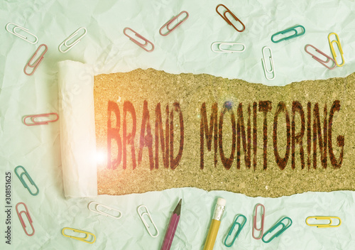 Conceptual hand writing showing Brand Monitoring. Concept meaning process to proactively monitor the brand reputation Stationary and torn cardboard on a wooden classic table backdrop photo