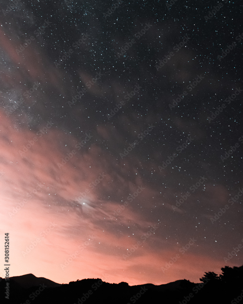 Naklejka premium Starry night with pinky clouds.