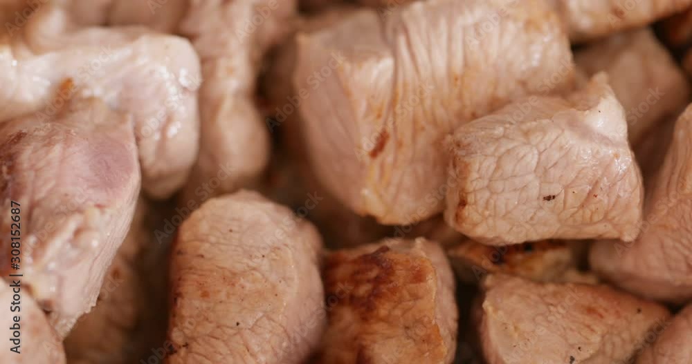 Pork chunks frying at high heat in frying pan, close-up Pork chunks frying at high heat in frying pan, close-up
