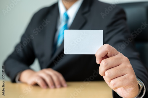 Business men wear suits sitting at desks and showing white card