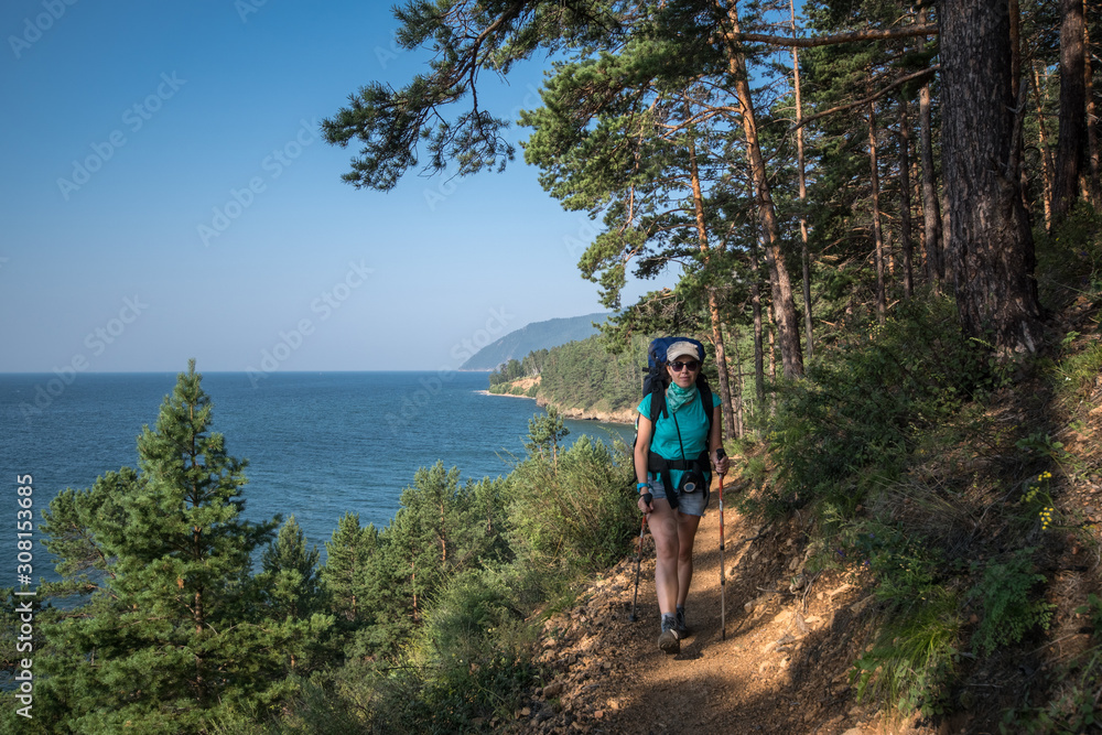 A girl travels along a hiking trail along Lake Baikal
