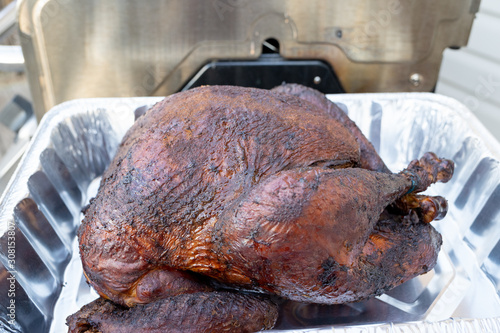 Smoked turkey sitting in aluminum foil pan