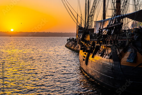 HMS Surprise ship, a tall modern replica of HMS Rose docked at Maritime Museum on the waterfront harbor bay in San Diego, Southern California at sunset.