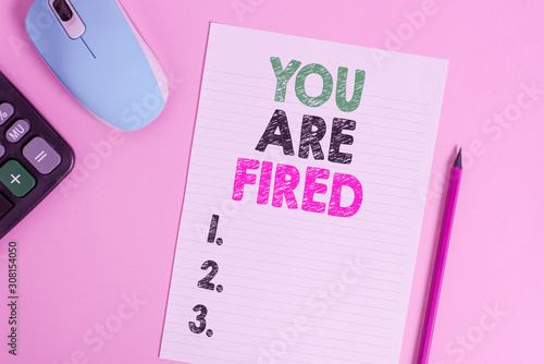 Text sign showing You Are Fired. Business photo text Getting out from the job and become jobless not end the career Electronic calculator wire mouse striped sheet pencil colored background photo
