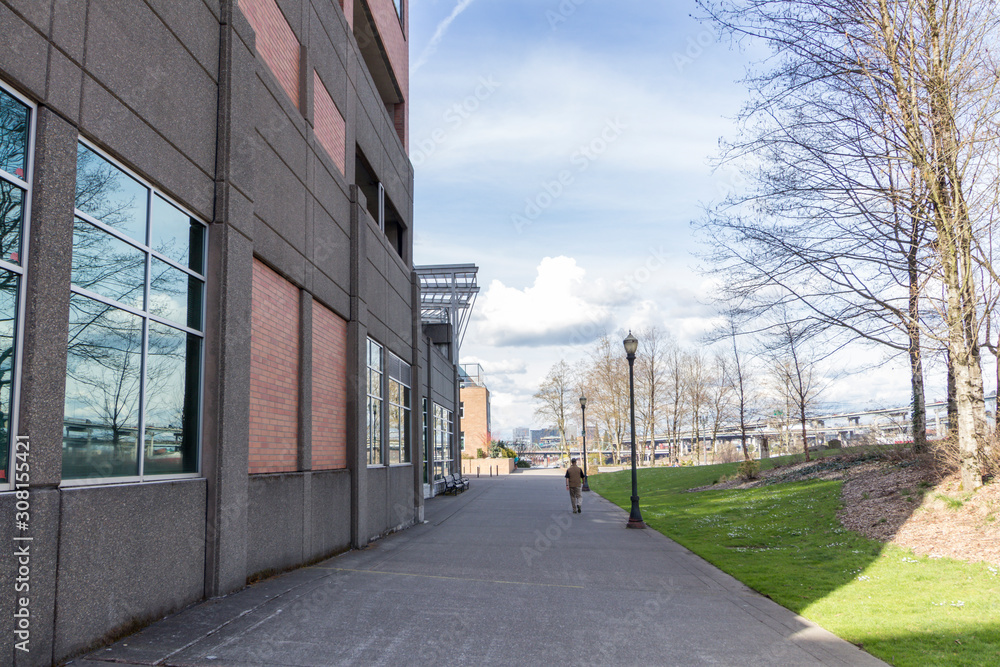 a person walking on the walkway next to a building in Portland, Oregon.