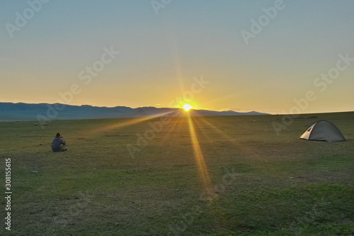 Sonnenuntergang in Steppe mit einsamen Zelt und Fotograf in weiter Landschaft, Bulgan, Mongolei photo