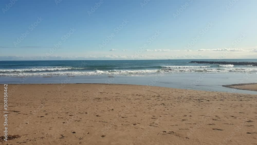 deserted beach waves of calm blue sea and clouds on the horizon deserted beach waves of calm blue sea and clouds on the horizon