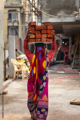 A woman carrying bricks on her head in Delhi, India