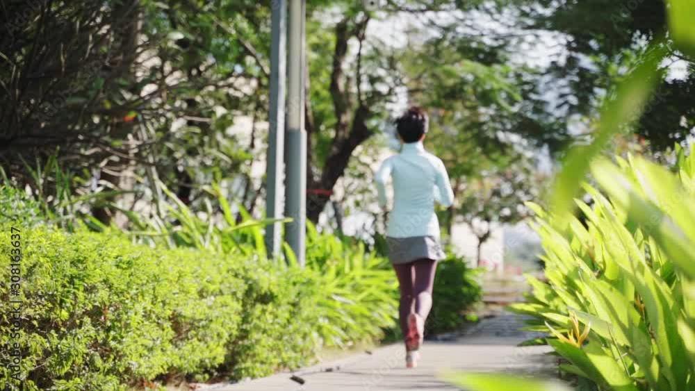 Asian beauty jogging in city park in morning slow motion Asian beauty jogging in city park in morning slow motion