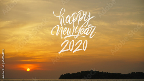 Happy new year 2020 hand lattering with beautiful yellow orange sky sunset or sunrise beach photo