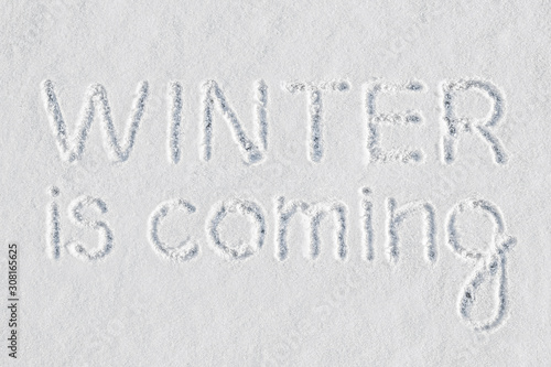 Obraz na płótnie The well-known expression Winter is Coming written with a finger on fresh snow m
