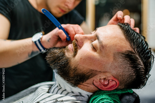 A man in a barbershop caring for his beard
