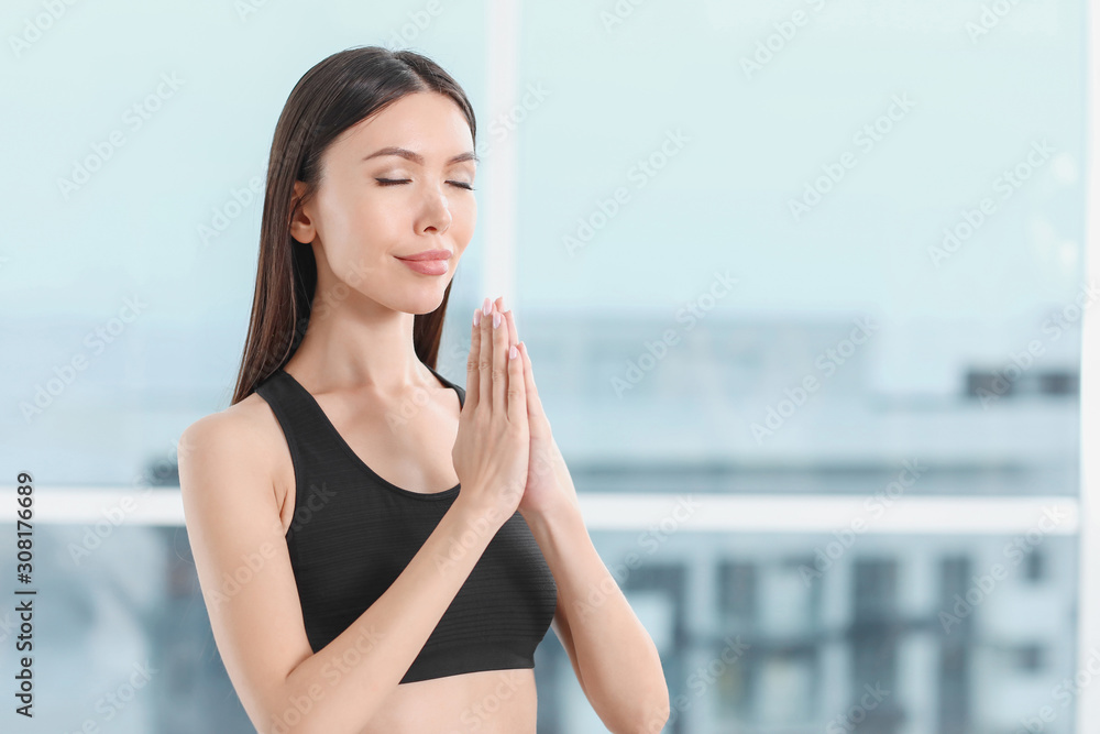 Sporty young woman practicing yoga in gym