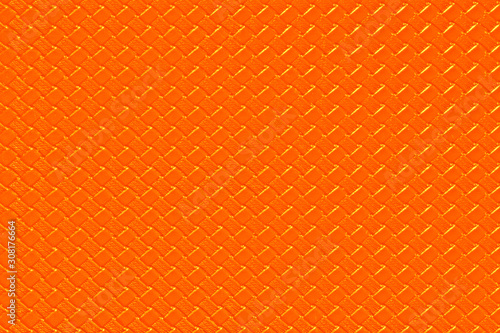 Bright orange leather background with imitation weave texture. Glossy dermantine, artificial leather structure. Fake woven leather wicker textured surface.
