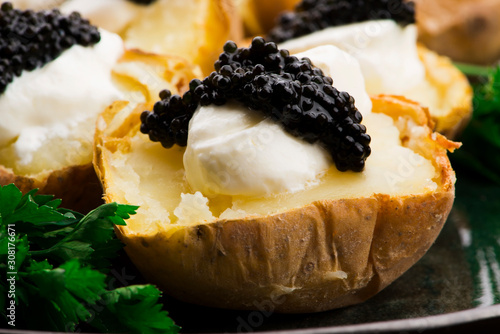 Foto Baked potato with spiced cream cheese and caviar