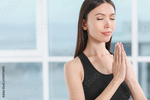 Sporty young woman practicing yoga in gym
