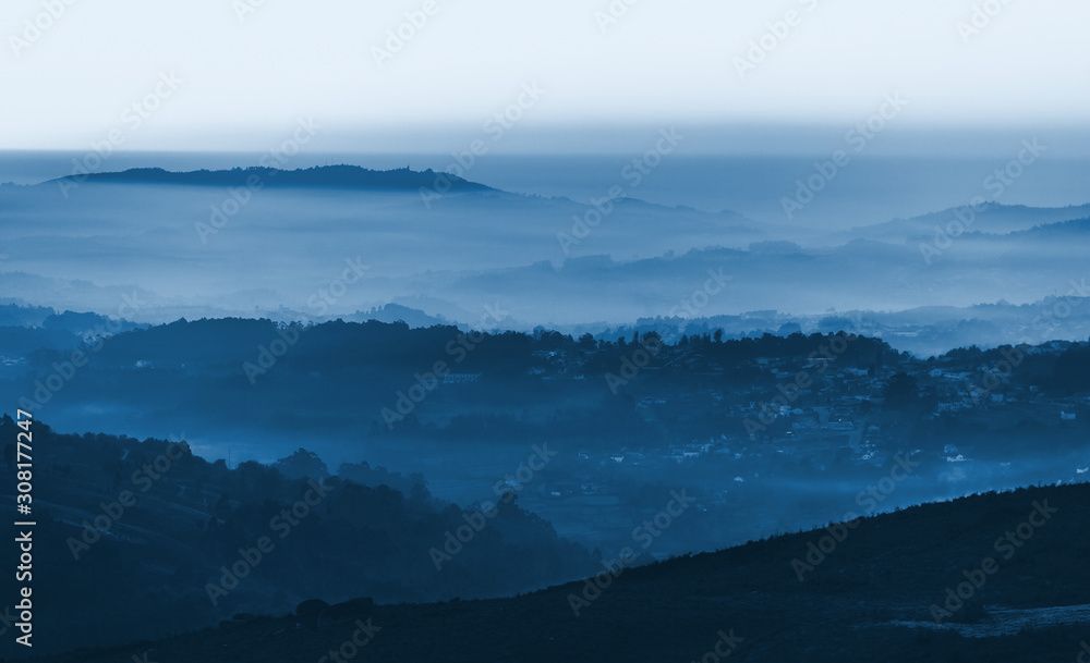 Layers of foggy mountains blue toned