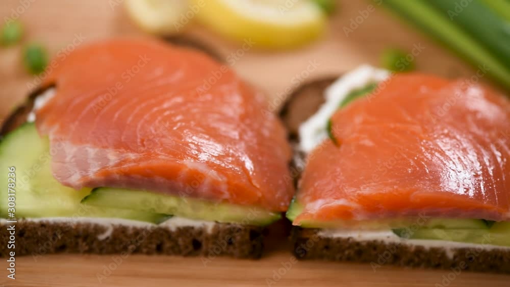 Rye bread sandwich with smoked salmon, cream cheese and cucumber. Closeup view. Healthy snack or appetizer Rye bread sandwich with smoked salmon, cream cheese and cucumber. Closeup view. Healthy snack or appetizer
