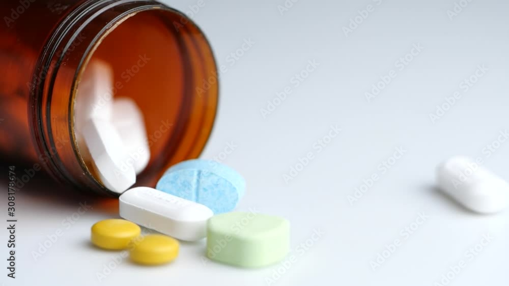 Close-up of falling and spilling pills in slow motion Close-up of falling and spilling pills in slow motion
