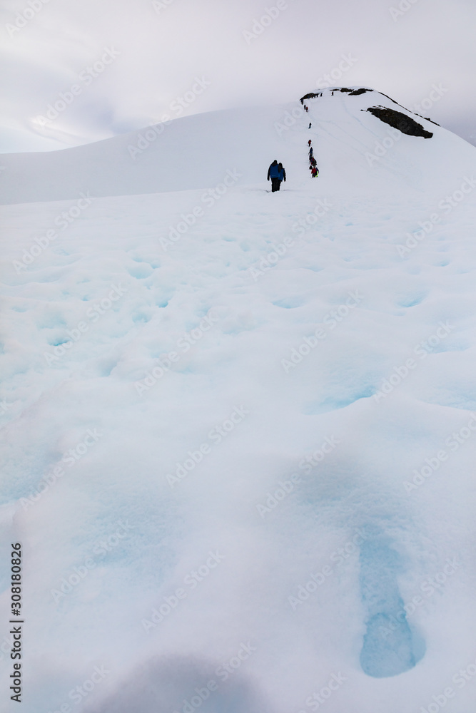 Tourists climbing a hill at Brown Base, Antarctica Tourists climbing a hill at Brown Base, Antarctica