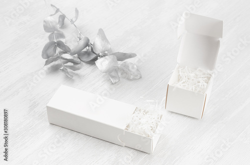 Elegant white blank open two gift boxes - square, rectangle filler mock up on wood board silver branch side view for design, branding identity, advertising.