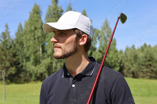 Man playing golf on beautiful sunny green golf course.