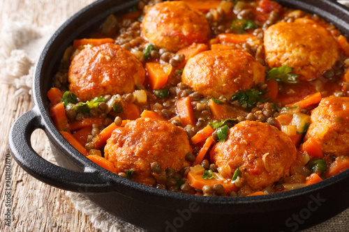 meatballs with a side dish of lentils and vegetables in tomato sauce close-up in a pan. horizontal