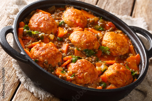 Tasty meatballs served with lentils and vegetables close-up in a pan on the table. horizontal