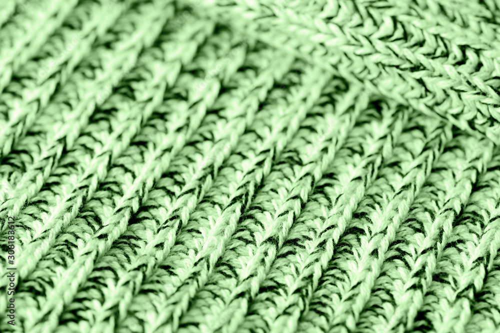 Knitted woolen texture close up. Textile background green color toned