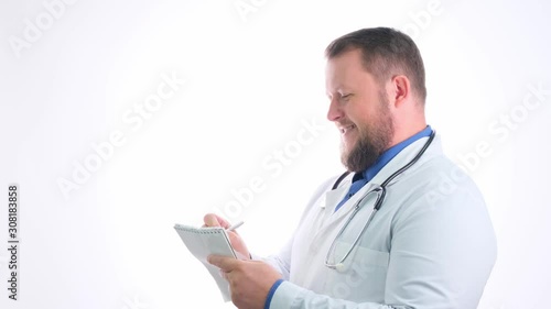 bearded smiling doctor man in a white coat makes a journal entry, close-up, copy space