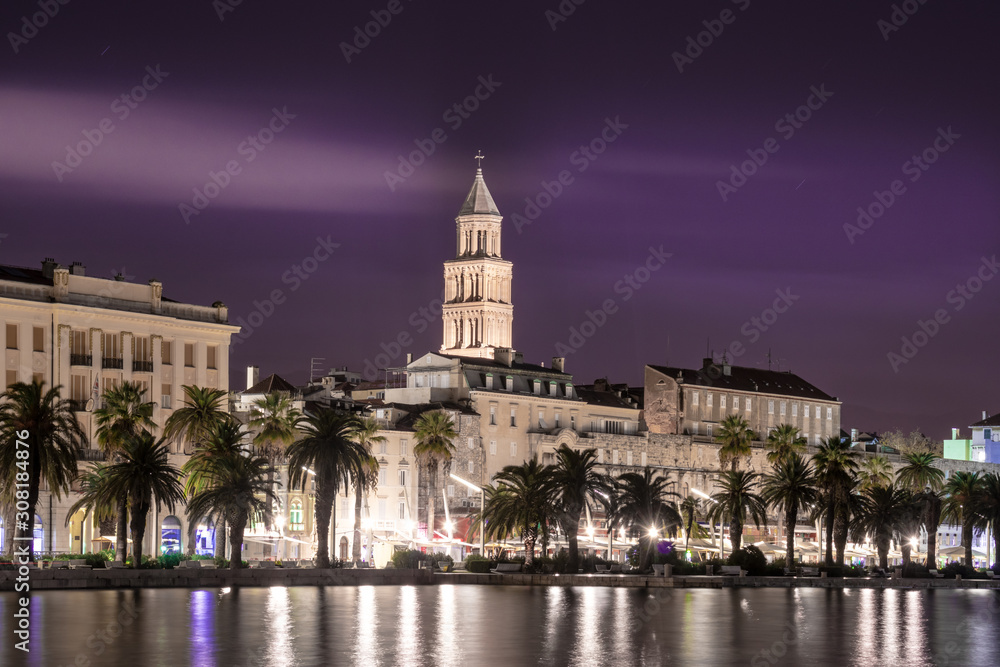 Split, Croatia at night. Long exposure photo with many lights. Bell tower of Saint Dominus cathedral seen above the buildings.
