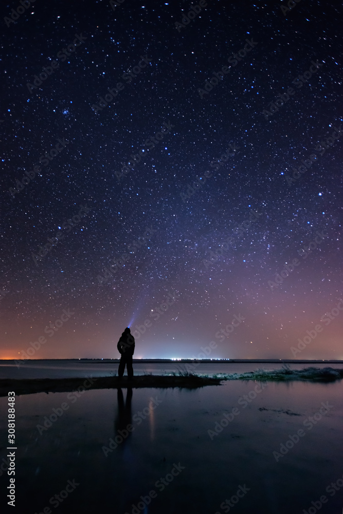 Lonely man at the beach under the starry sky