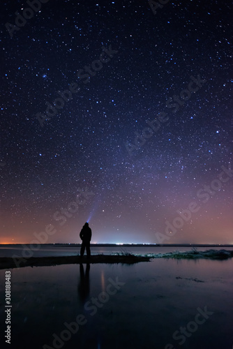 Lonely man at the beach under the starry sky