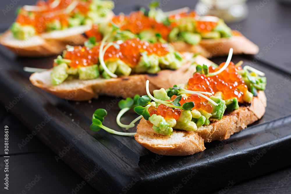 Sandwiches with salmon red caviar and salsa with avocado. Sandwich for lunch. Delicious food.