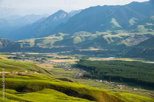 Peaceful village in valley with forest and river