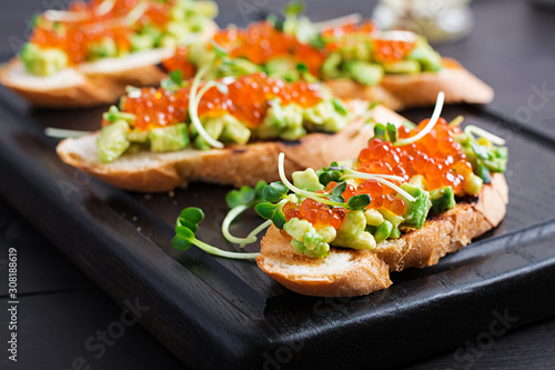 Sandwiches with salmon red caviar and salsa with avocado. Sandwich for lunch. Delicious food.