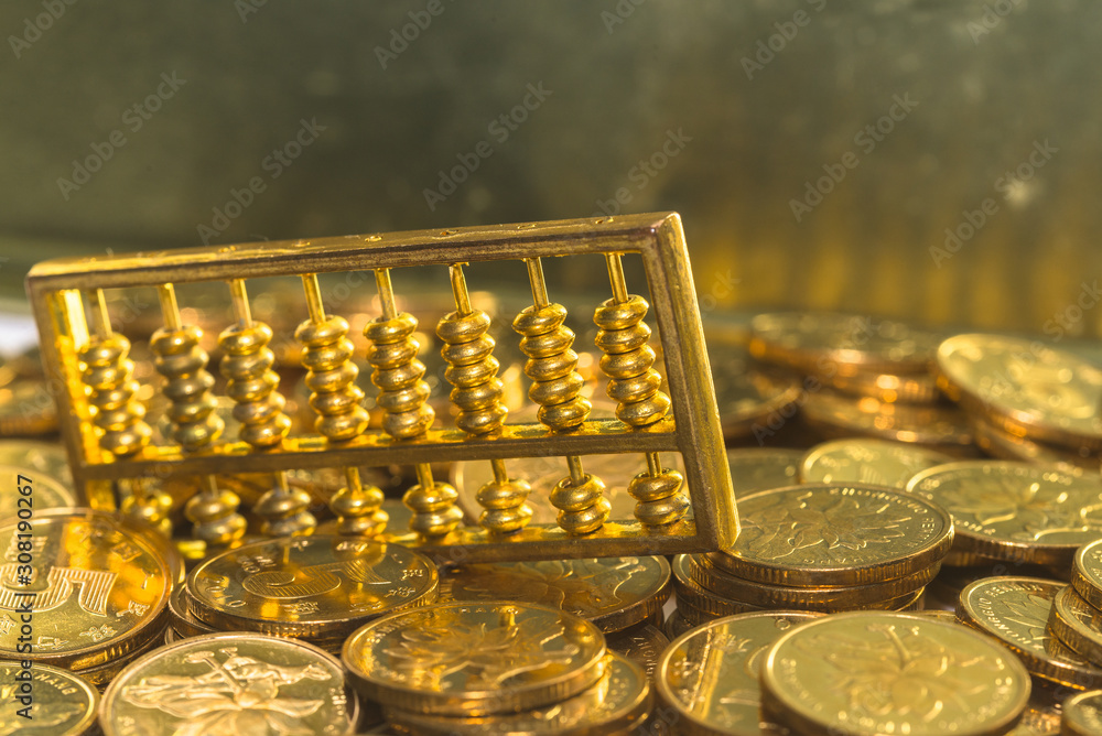 A gold abacus was placed on the background of the pile of COINS A gold abacus was placed on the background of the pile of COINS