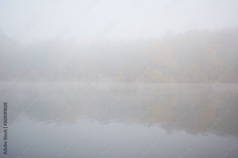 Fototapeta premium Landscape of an early morning lake and a boat with a fisherman