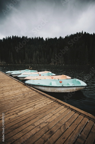 Boats tied to a wooden pier on the lake 